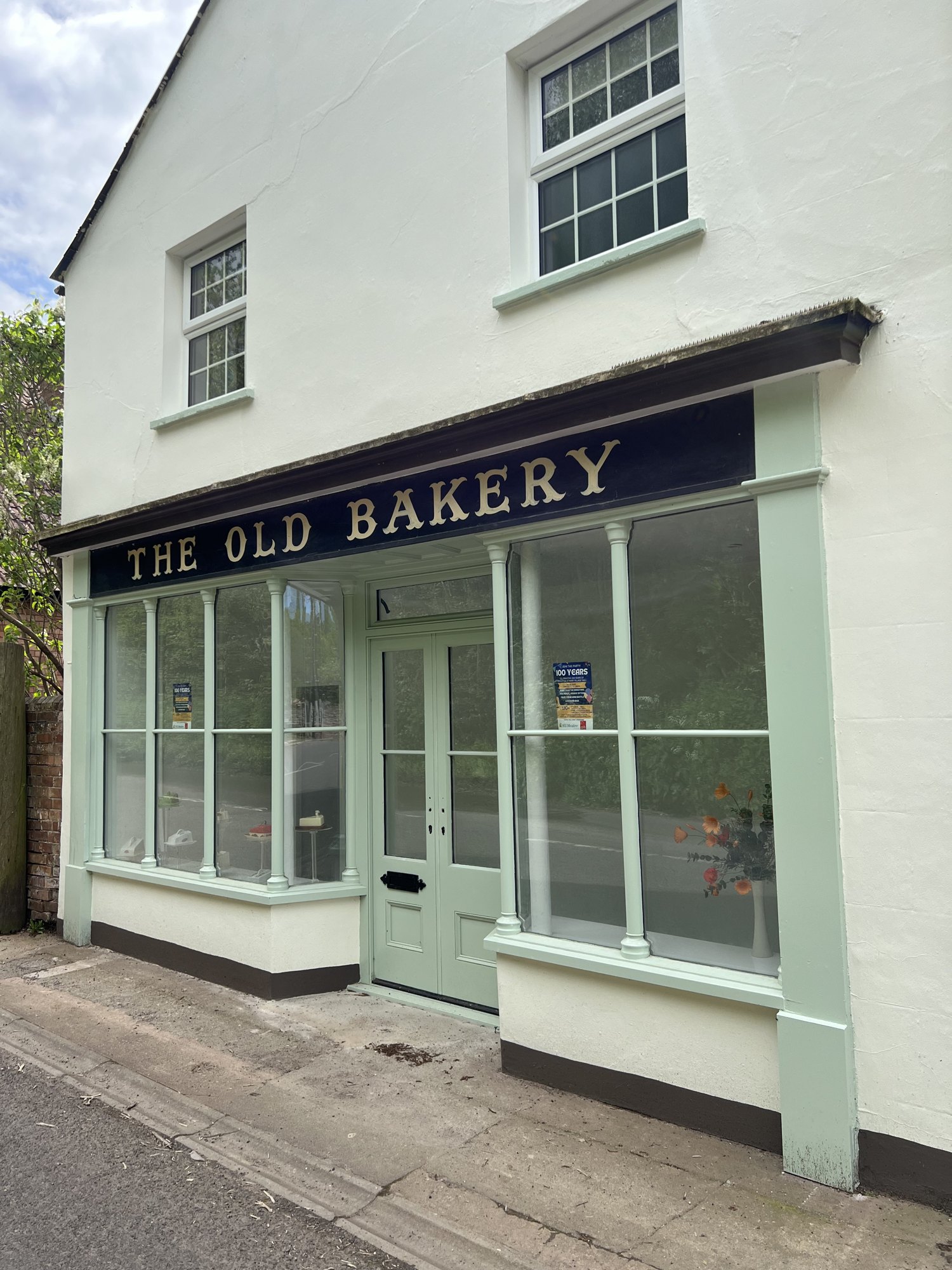The restored Old Bakery frontage with its sage green timber shopfront beneath the painted sign