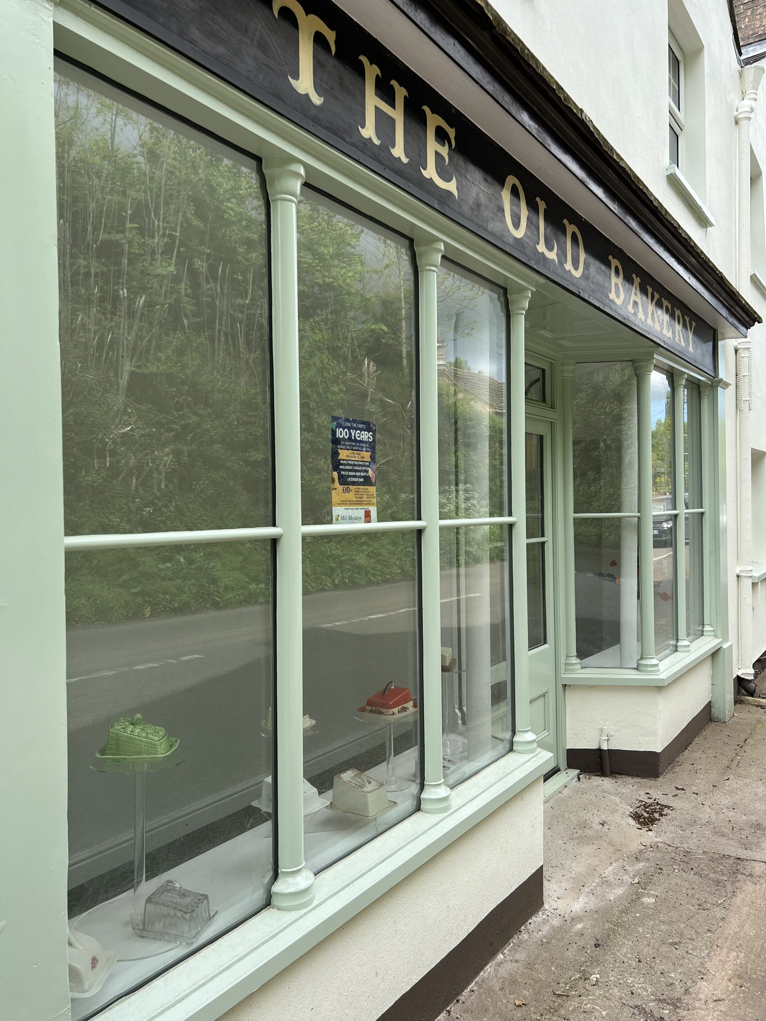 The restored timber shopfront at The Old Bakery with curved pillars & tall glazed windows