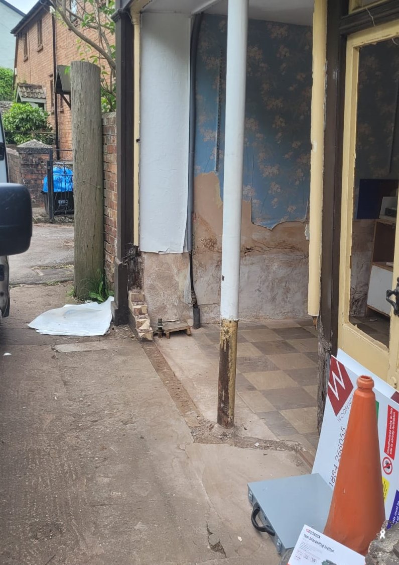 Damaged corner of The Old Bakery shopfront with the frontage removed & temporary supports in place